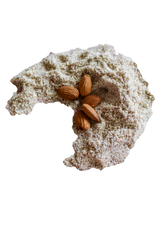 Moon shaped pile of Almond Flour with five whole raw almonds.