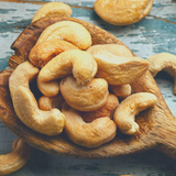 Roasted Unsalted Cashews sitting on rustic timber serving spoon.