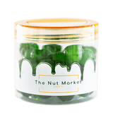 Side on view of Nut Market jar with Glace Cherries Green inside.