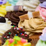 Close up of Jersey Caramel on top of cupcake, surrounded by colourful iced cupcakes.