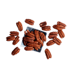Scattered raw Pecans for sale on a square plate at The Nut Market