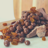 Milk Chocolate Sultanas spilling off chunks of milk chocolate.