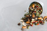 Goji Berry Trail Mix spilling out of small ramekin onto concrete benchtop.
