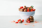 Milk Chocolate Strawberries in bowl with fresh strawberries, on light grey background.