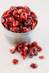 Small stainless ramekin filled with ruby red Dried Cranberries.
