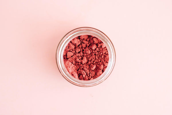 Açai powder superfood in a jar on a pink background