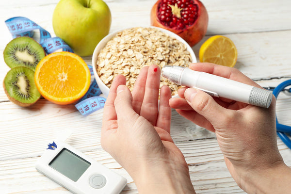 Female checking blood sugar level on background with diabetic accessories