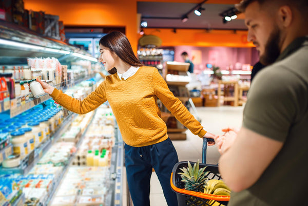 Couple in a supermarket with the female checking nutrition labels