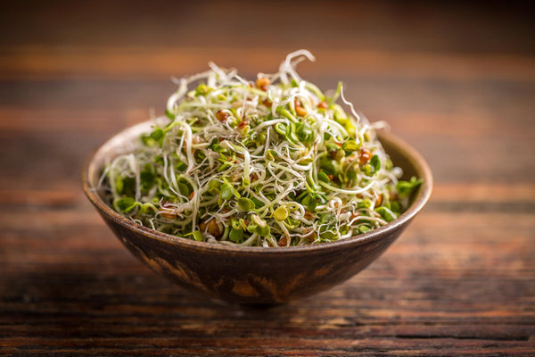 A wooden bowl full of sprouts.