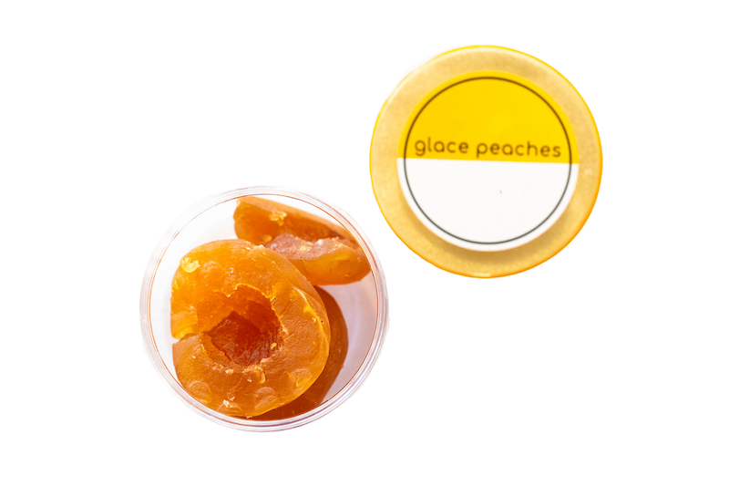 An open container of glacé peaches