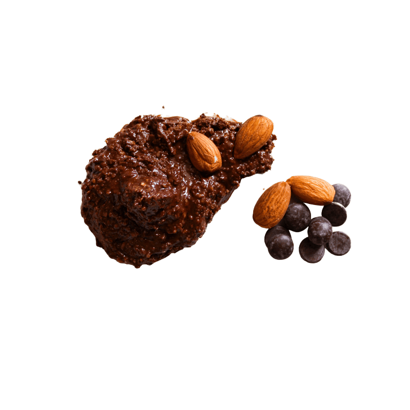 Small pile of Dark Chocolate Chips and whole Dry Roasted Almonds sitting next to a smear of Chocolate Almond Butter. 