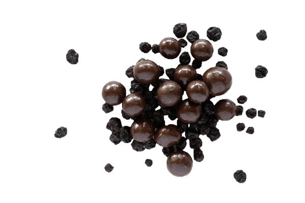 Pile of Dark Chocolate Blueberries with scattered dried blueberries.