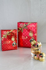 Christmas Gift Boxes of Mozart Kugeln with individual Mozart Balls scattered in front. 