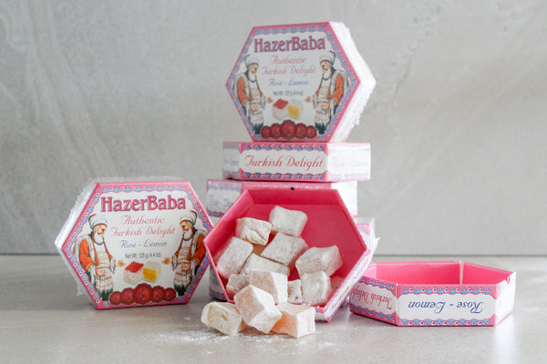 Hazer Baba Rose and Lemon Turkish Delight Mini Boxes stacked, with turkish delight spilling out onto concrete bench.