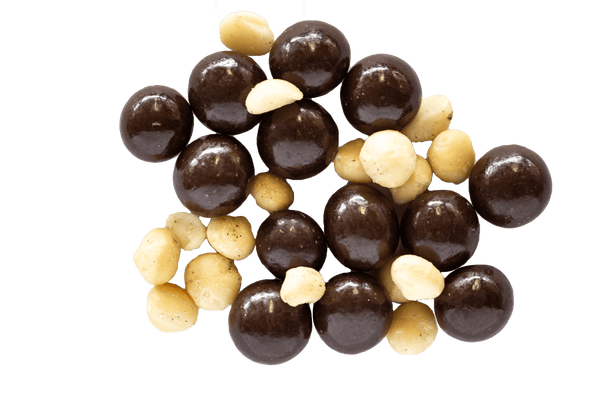 Pile of Dark Chocolate Macadamias with raw macadamia nuts scattered amongst them. 