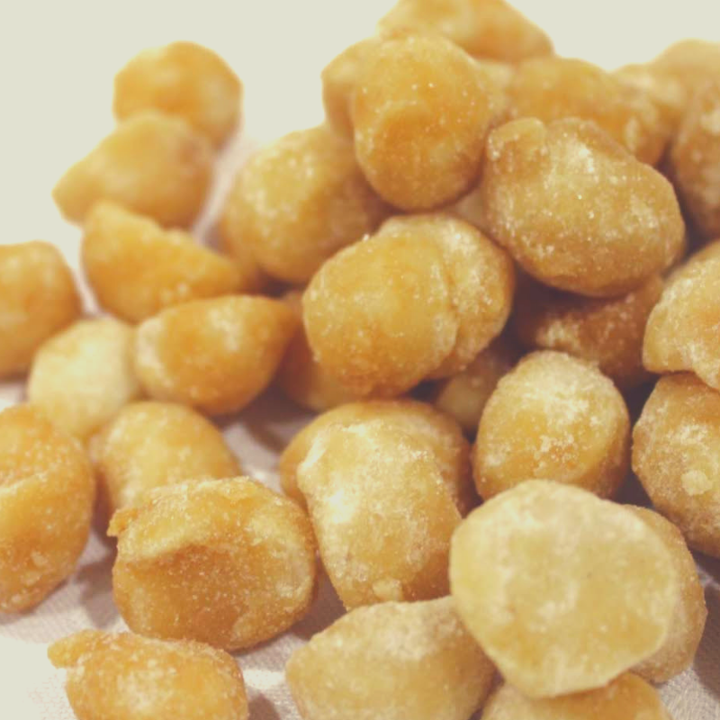 Close up of Honey Roasted Macadamias on white background.