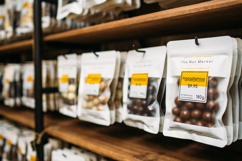 Nut Market packets of Milk Chocolate Macadamias on the shelf. 